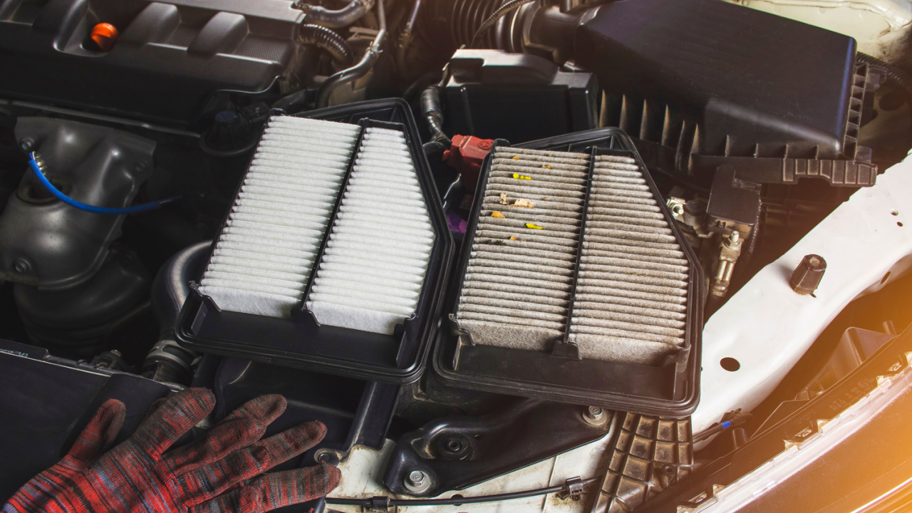 Car air filter with new and old placed on car chassis in engine room of a car