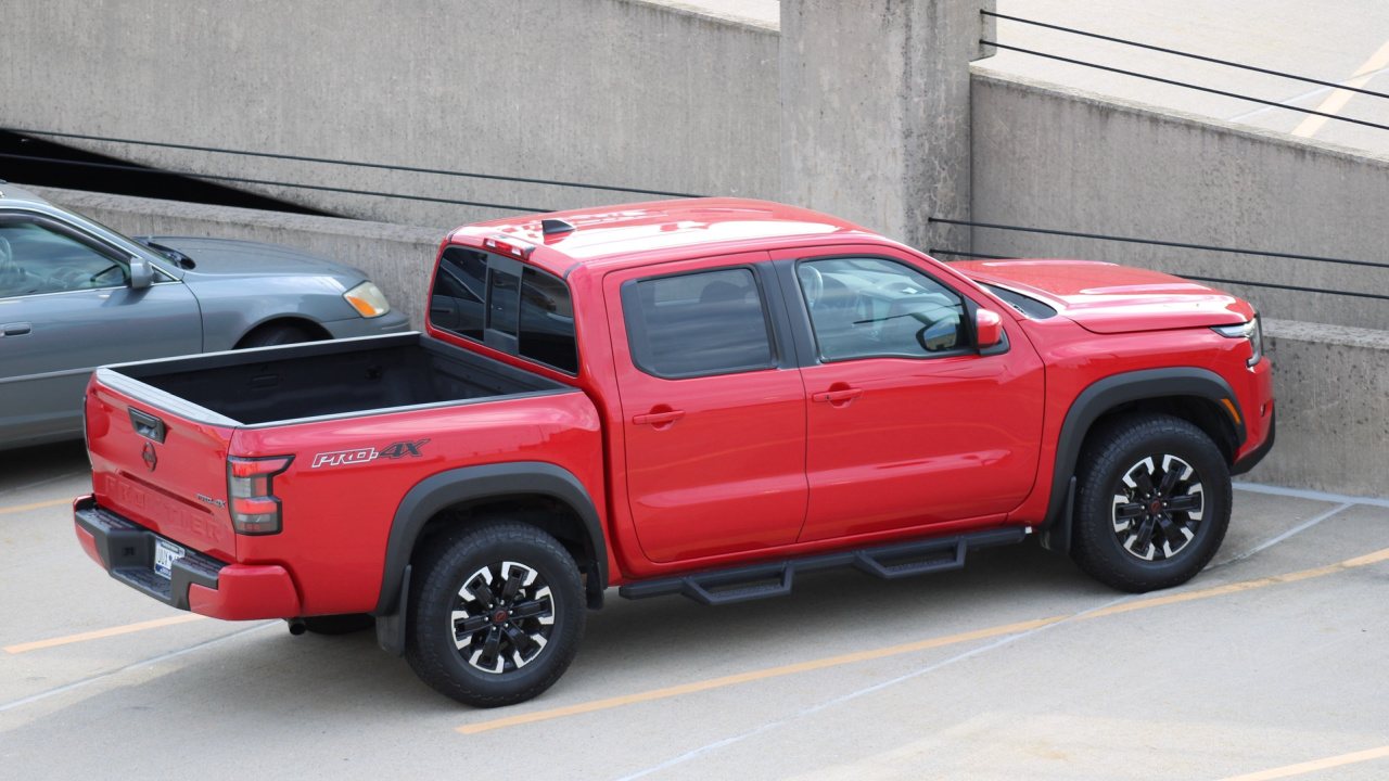 Nissan Frontier pickup truck red display. Nissan is part of the Renault Nissan Alliance.