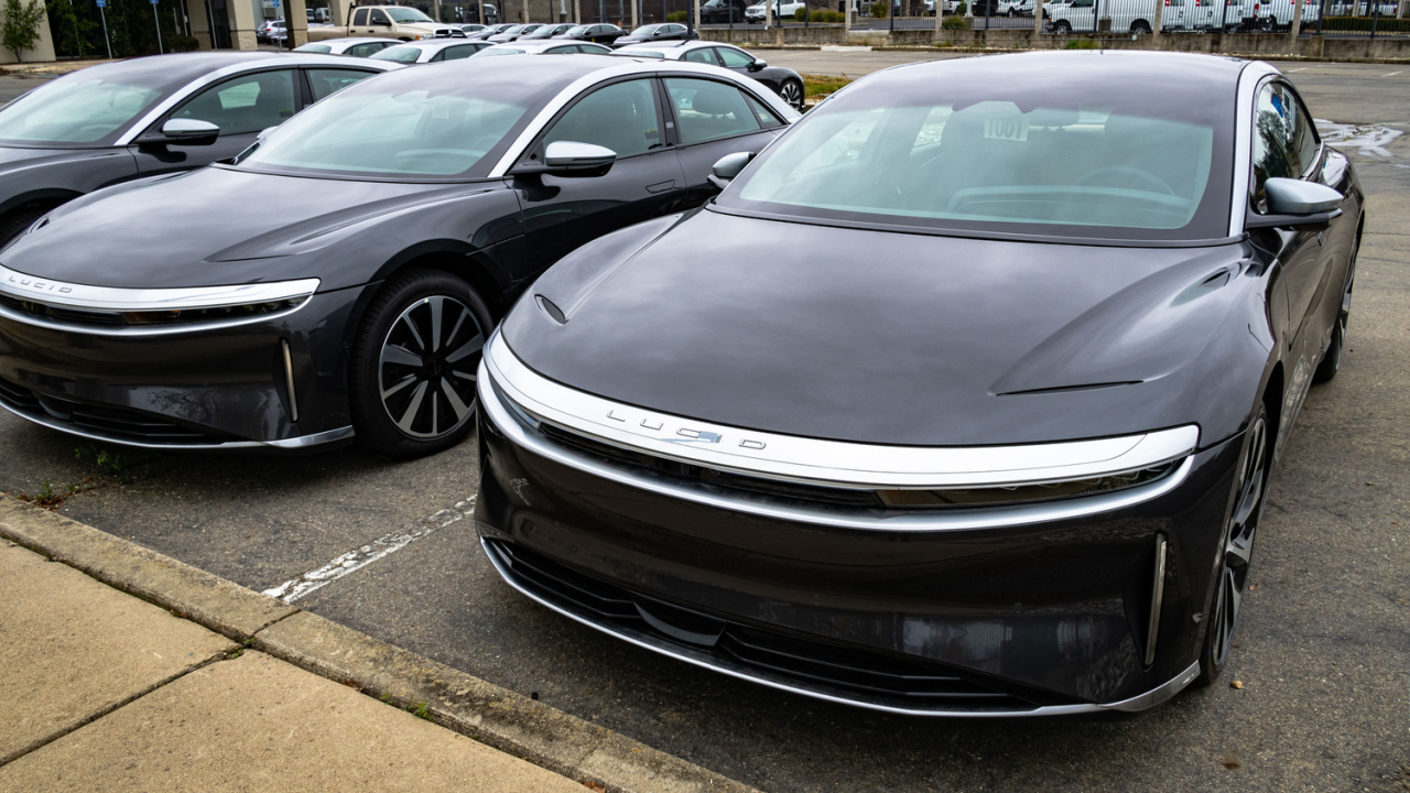 Photo of the front of two parked black Grand Touring Lucid Air luxury sedan electric vehicles. The cars get approximately 500 miles of range.