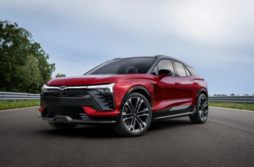 Three-quarter view of 2024 Chevrolet Blazer EV SS in Radient Red Tintcoat on a road with trees. Preproduction model shown. Actual production model may vary. 2024 Chevrolet Blazer EV available Spring 2023.