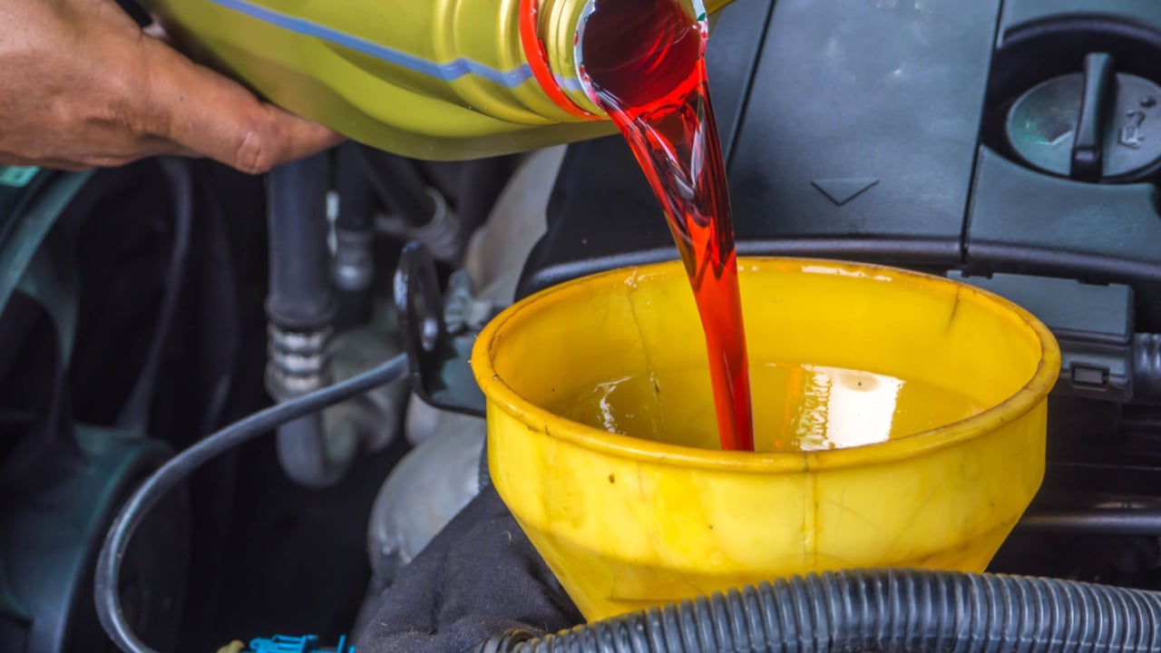 hand fill up in a car engine with transmission oil