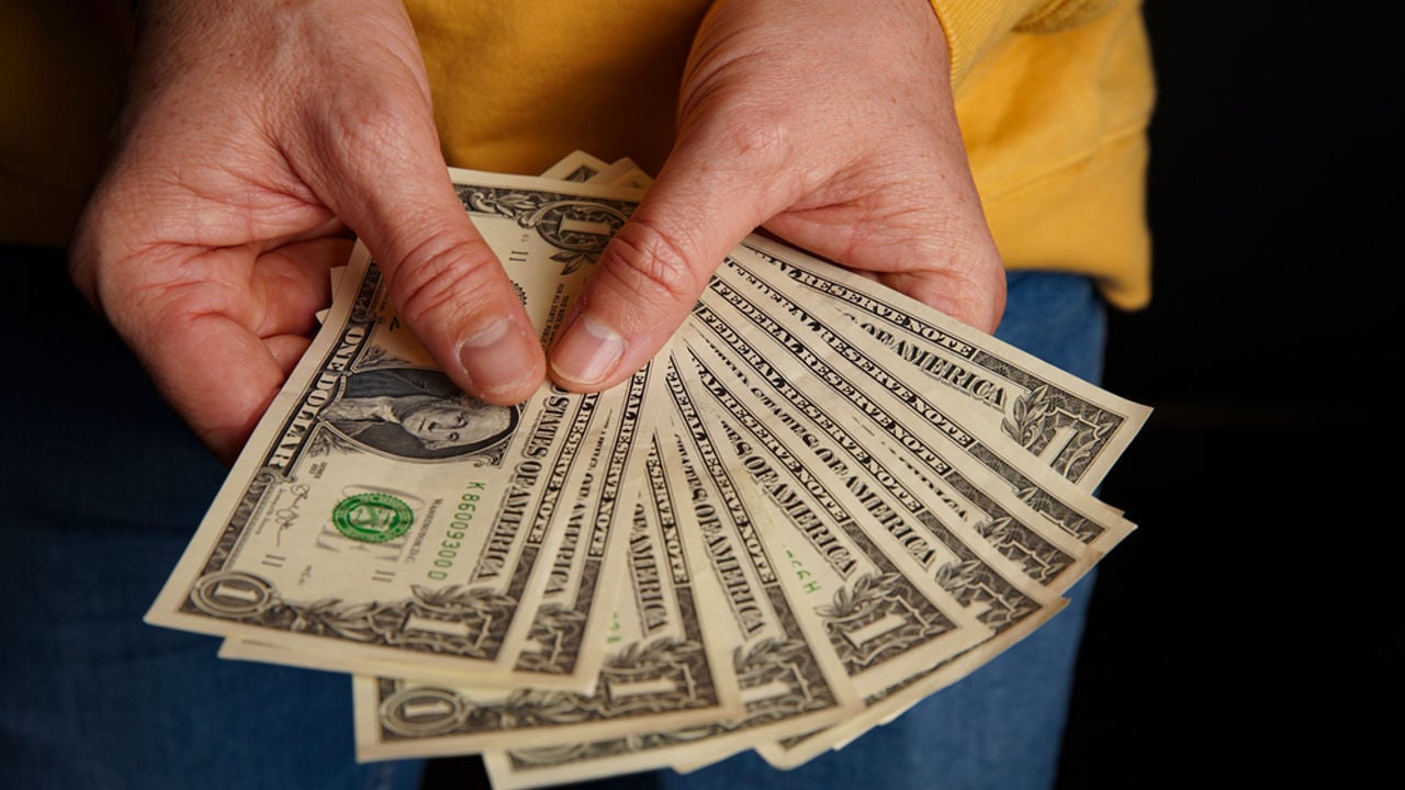 Dollar in hand. Top view of male hand holding one dollar banknotes. Currency paper money, bills in hand.