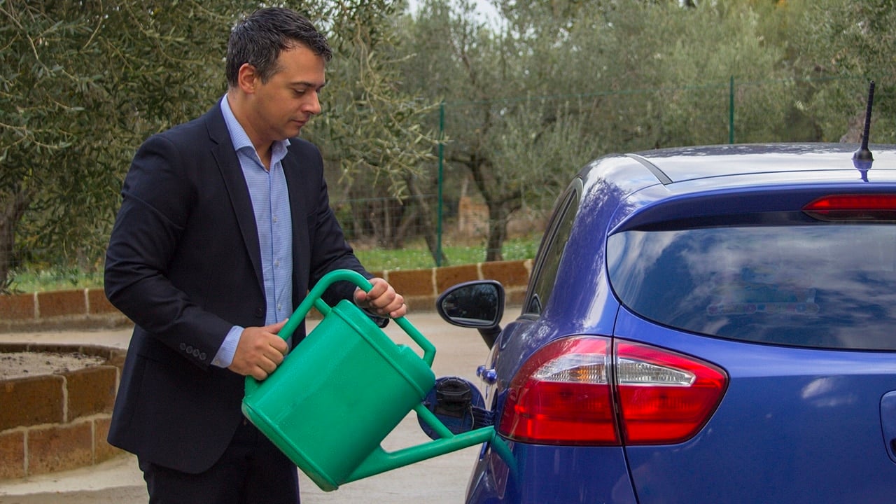 Man filling fuel tank of car with watering can