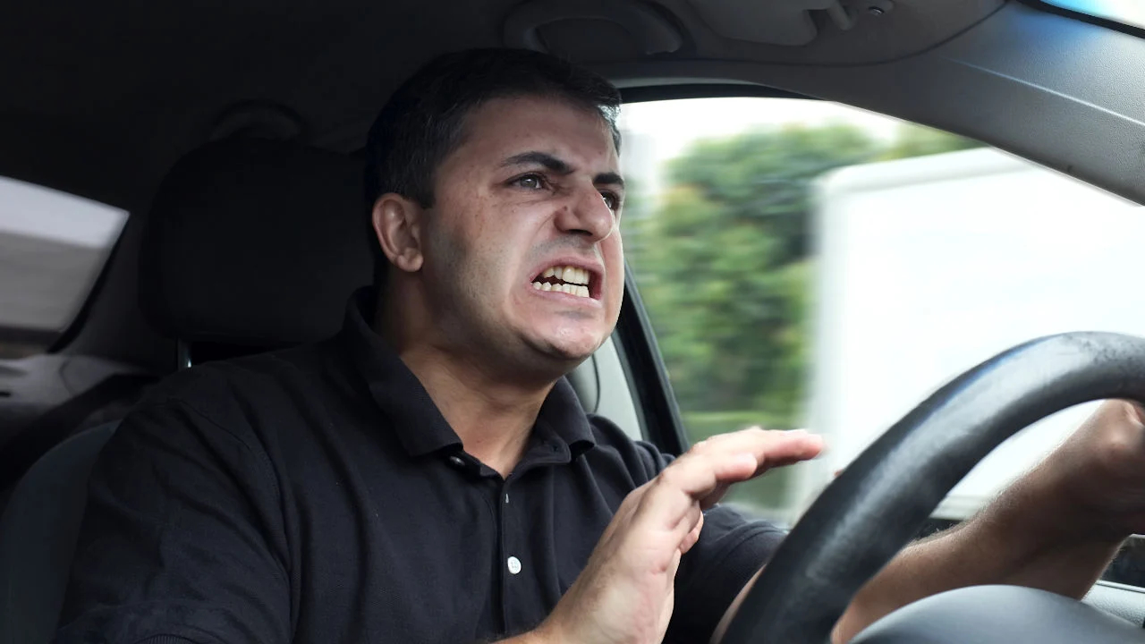 An image of an upset driver in a vehicle without seat belt