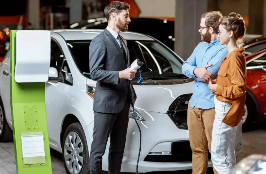 electric vehicle in car dealership, EV vehicle charging station, electric car sales, couple buying car