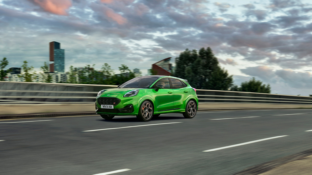 Ford Puma ST, front 3/4 view, highway, driving, green.