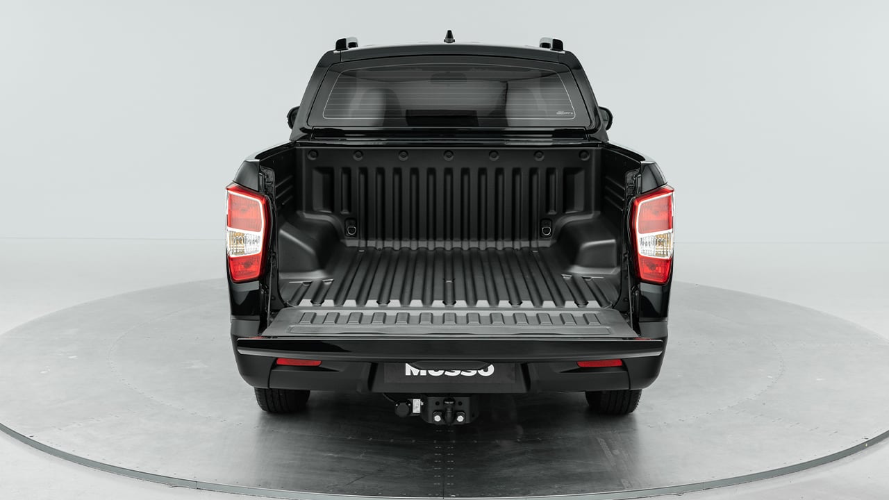 The rear end of a KGM Musso pickup truck, tailgate open