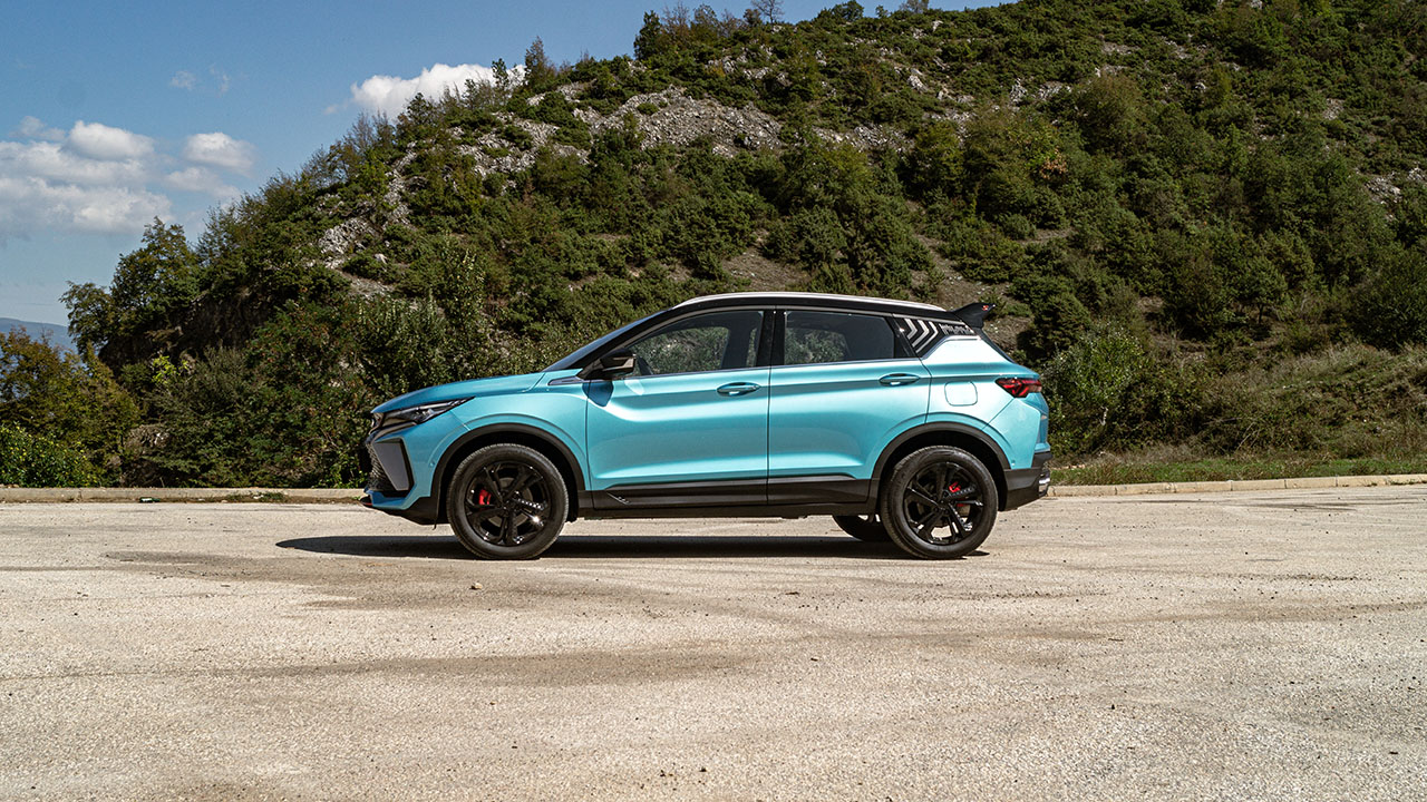 The side profile of a Geely Coolray in a mountainous area