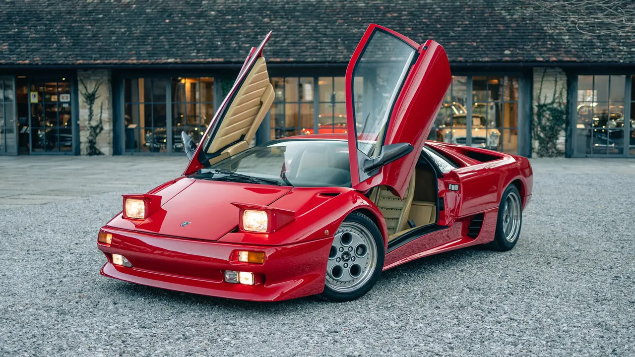 Red 1991 Lamborghini Diablo Parked With Doors Open And Lights On