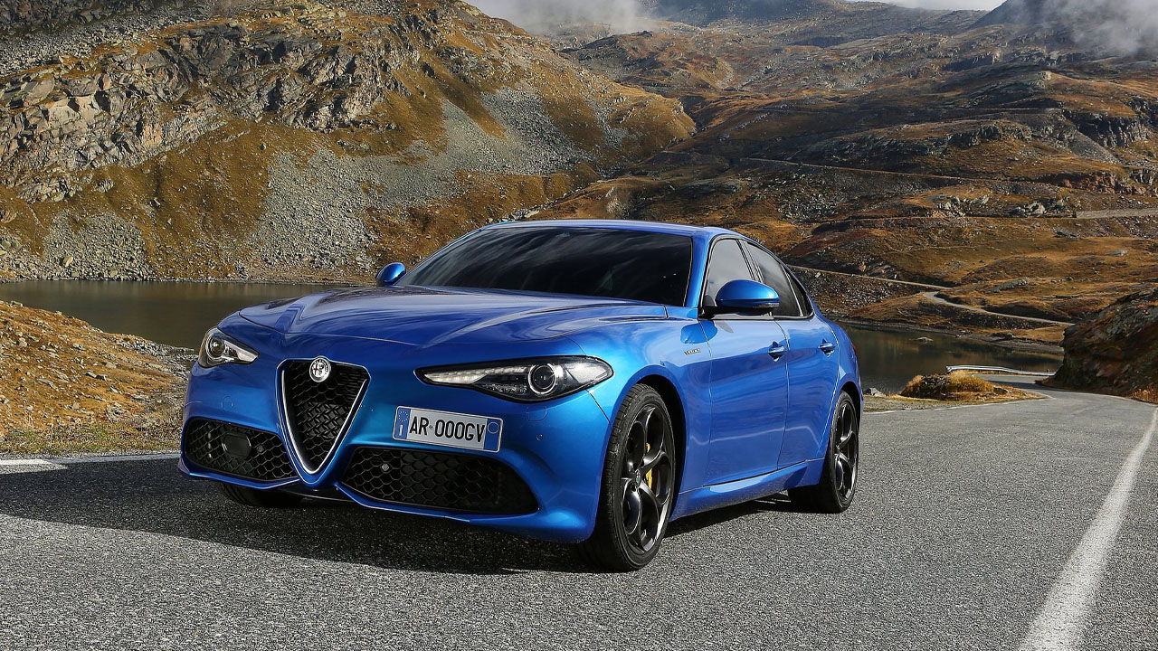 A blue Alfa Romeo Giulia on a mountain road, front 3/4 view