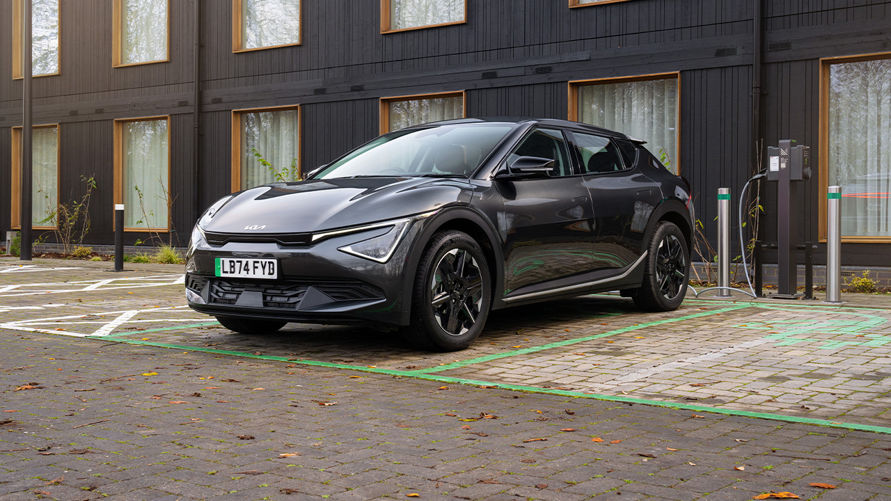 A black Kia EV6 at a charge point, front 3/4 view