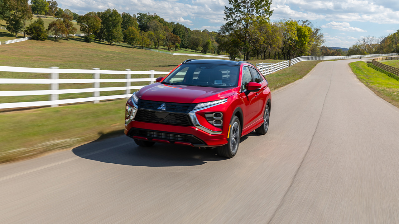 A red Mitsubishi Eclipse Cross on the move, front 3/4 view