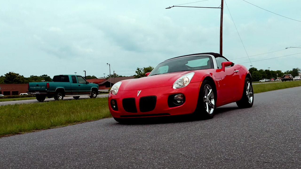 A red Pontiac Solstice GXP on the move, front 3/4 view