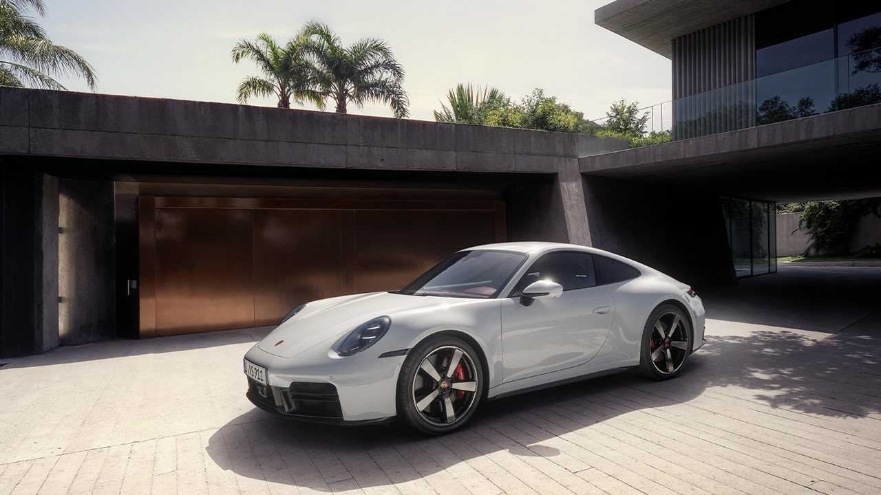 The 992.2 Porsche 911 Carrera in white, luxury home driveway, front 3/4 view