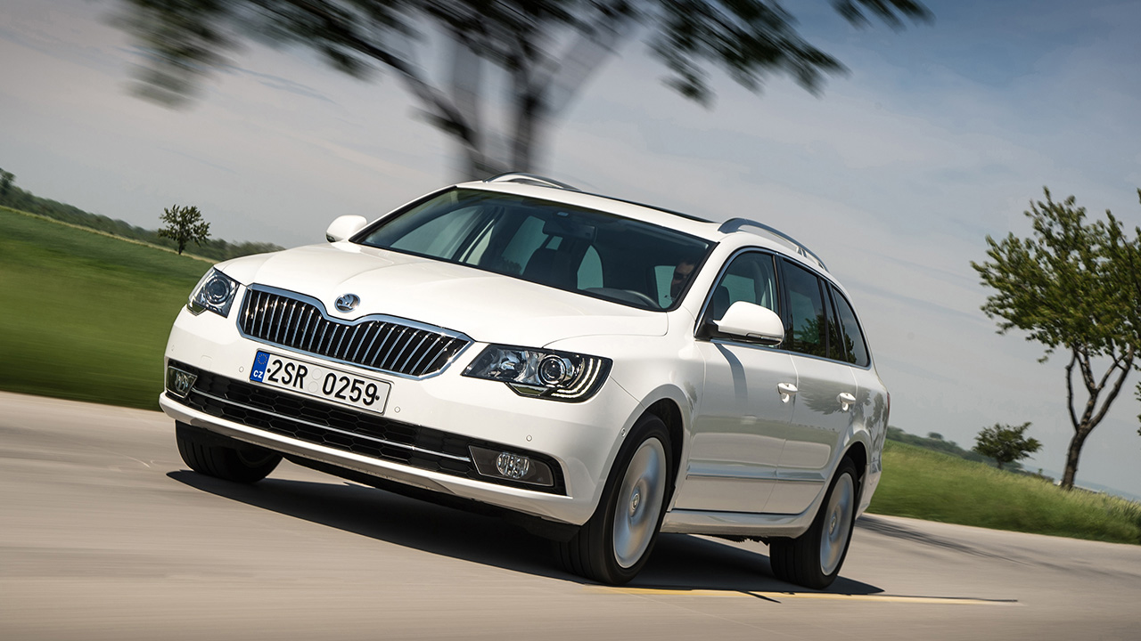 A white second generation Skoda Superb Combi, driving, front 3/4 view