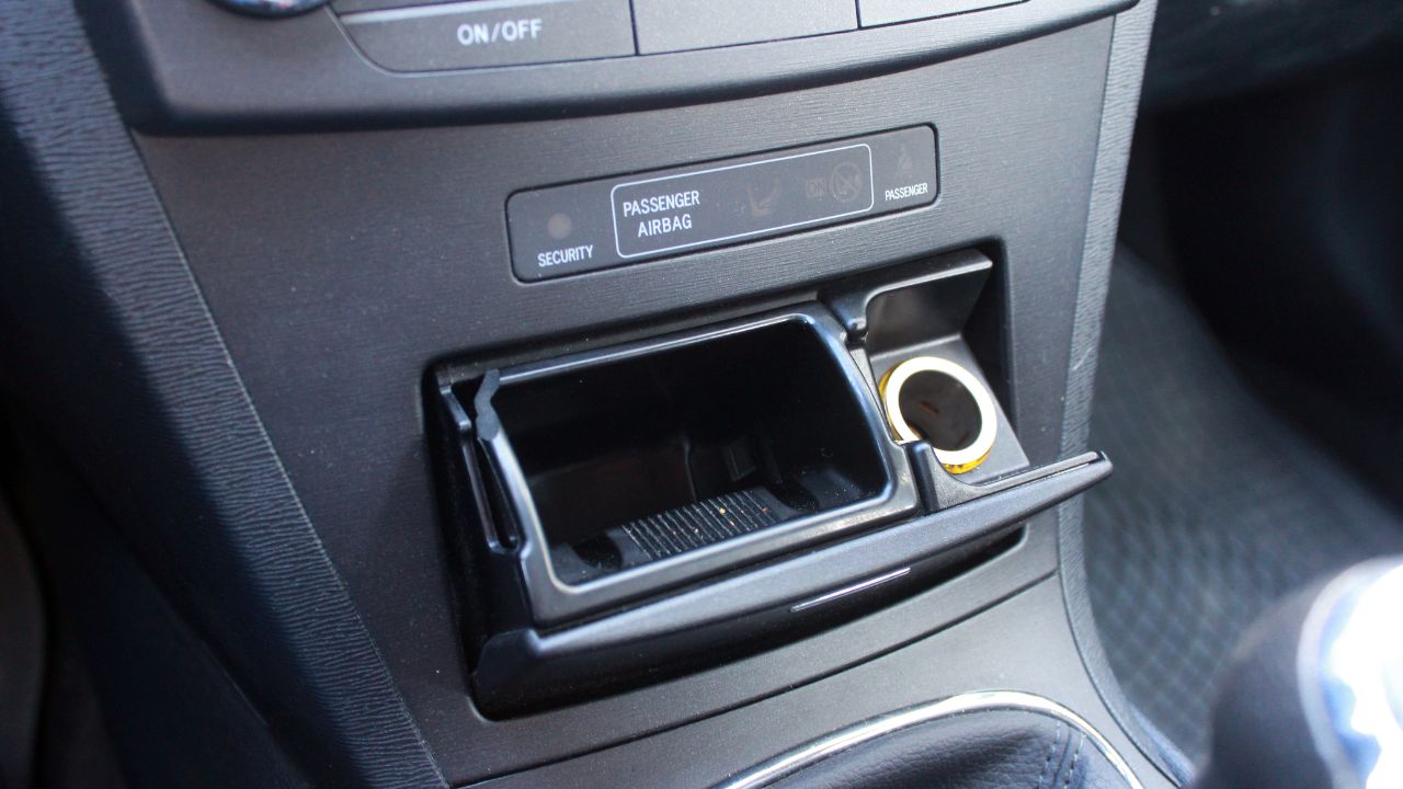 Open ashtray and cigarette lighter in the car. Car interior.