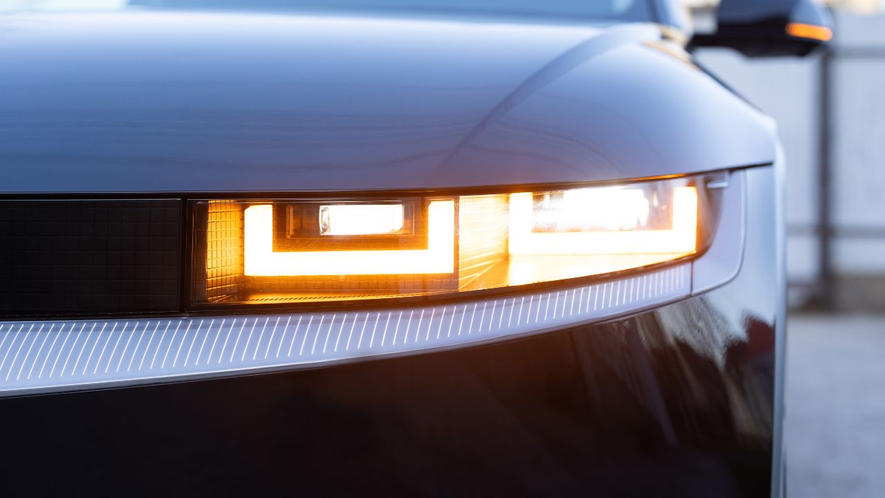 Car flashing light with blinking indicator. Emergency flashing car light lamp, warning sign. LED Headlight of a car Shining. Led light of a car shining bright. Nobody around to help