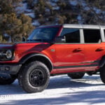 Orange 2022 Ford Bronco Wildtrack Parked In The Snow Front 3/4 View