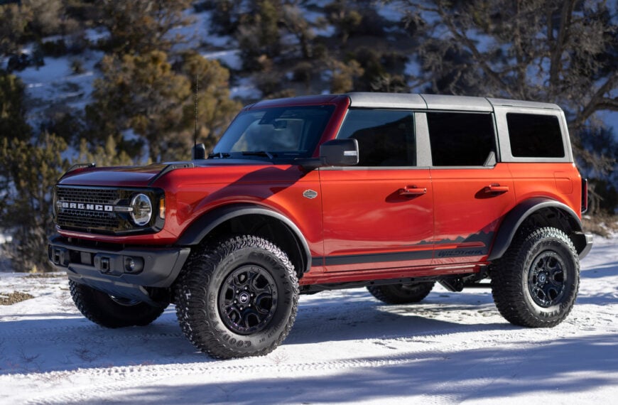 Orange 2022 Ford Bronco Wildtrack Parked In The Snow Front 3/4 View