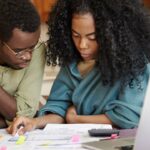 A couple reviewing their finances, analyzing family budget, thinking how to cut off expenses to be able to save money and buy new car