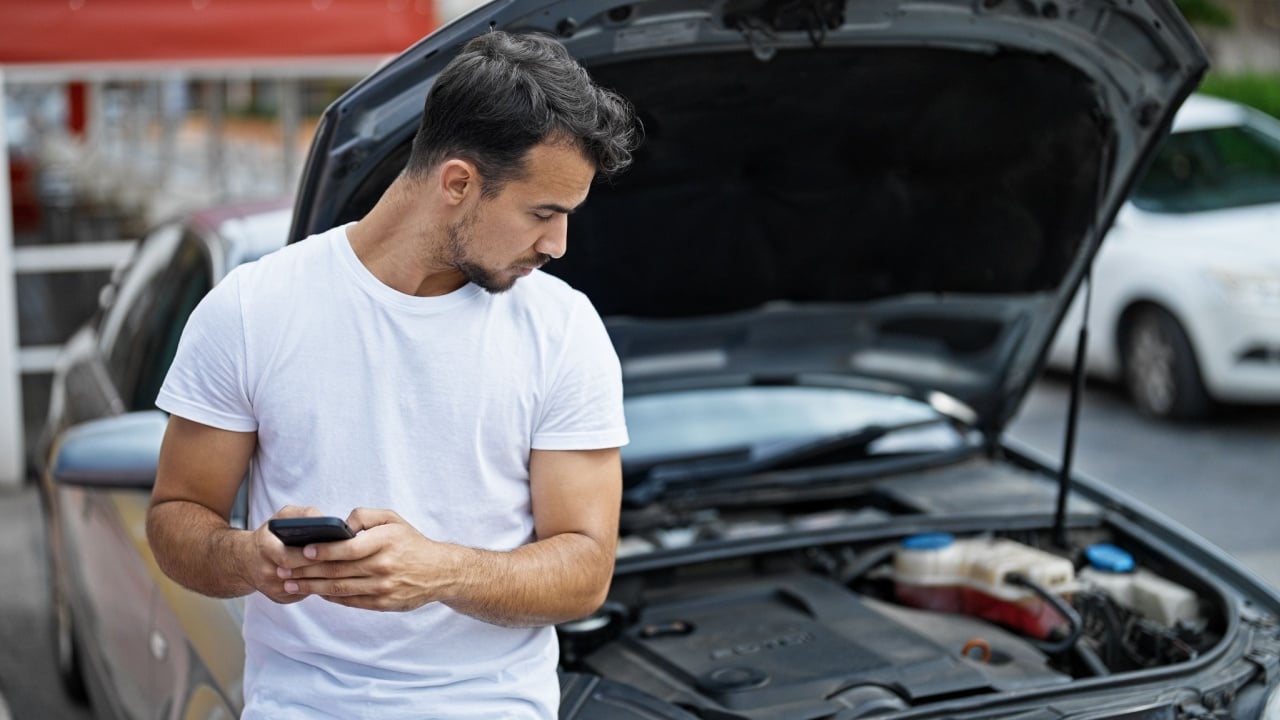 A man's car has broken down and needs to be repaired