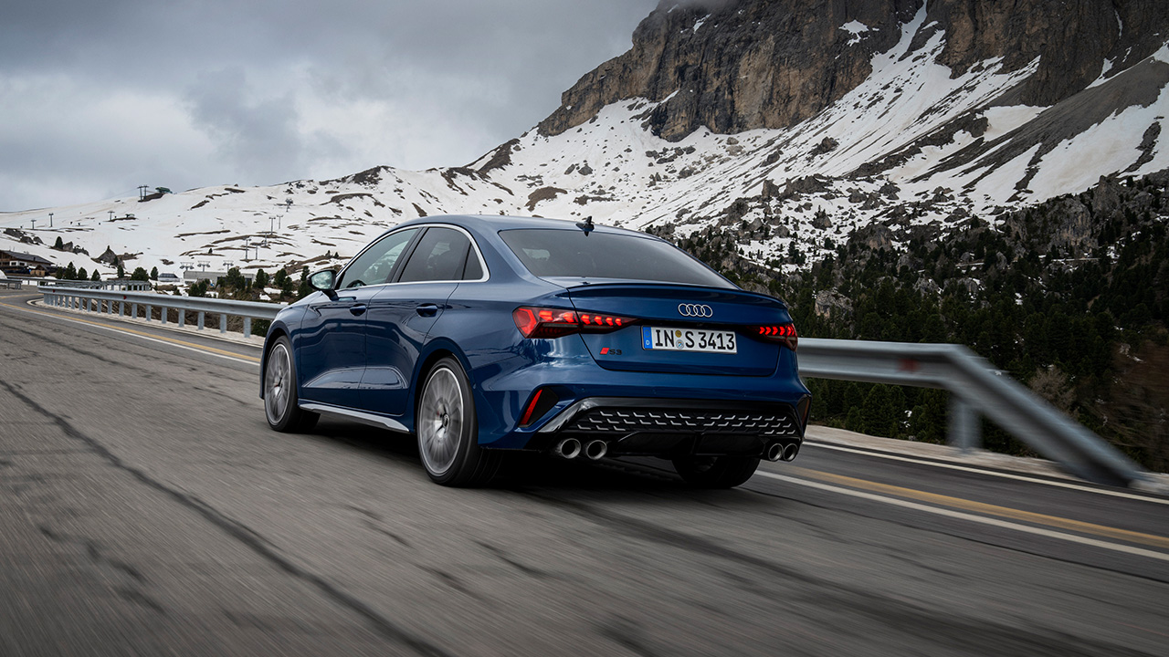 The Audi S3 sedan on the move on a mountain road, rear 3/4 view