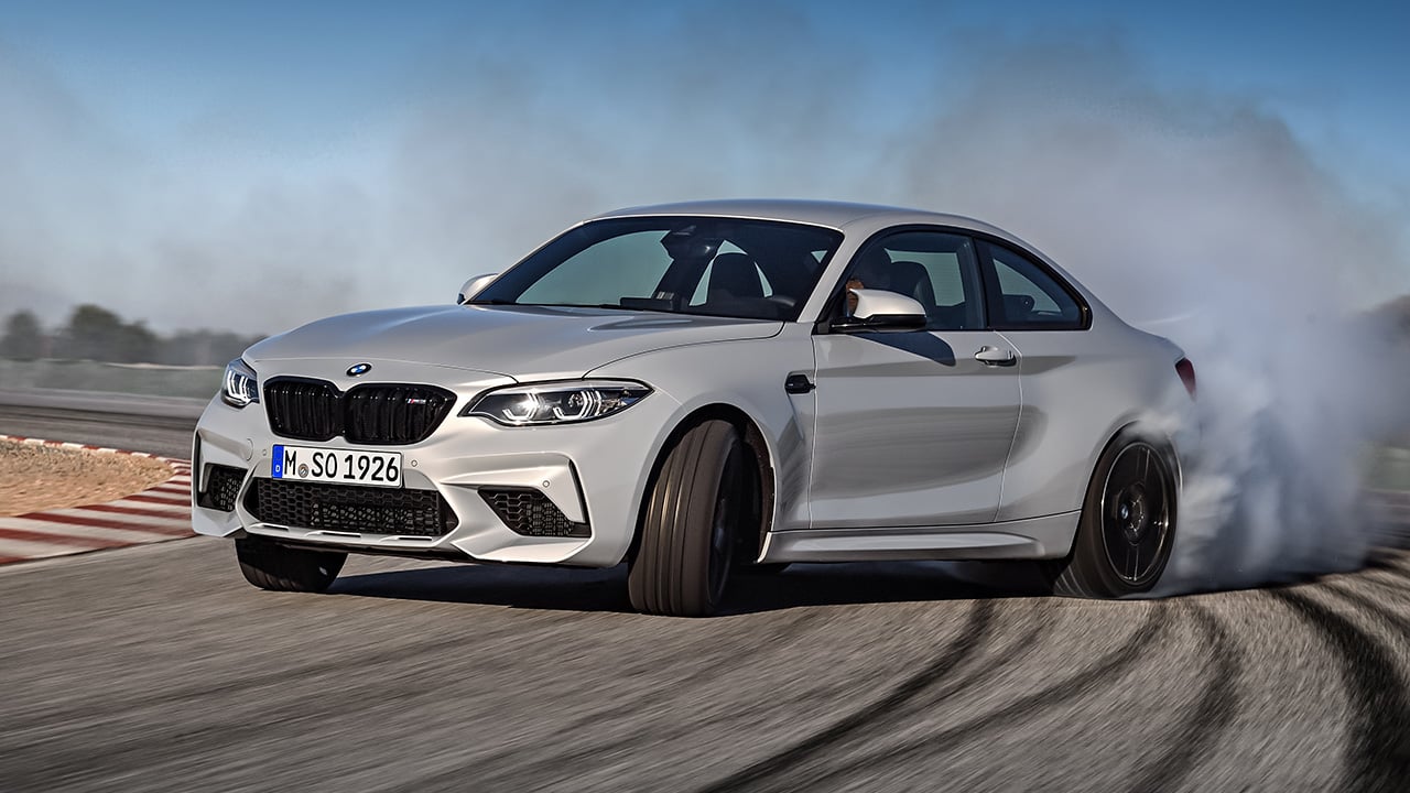 An F87 BMW M2 Competition getting sideways, front 3/4 view