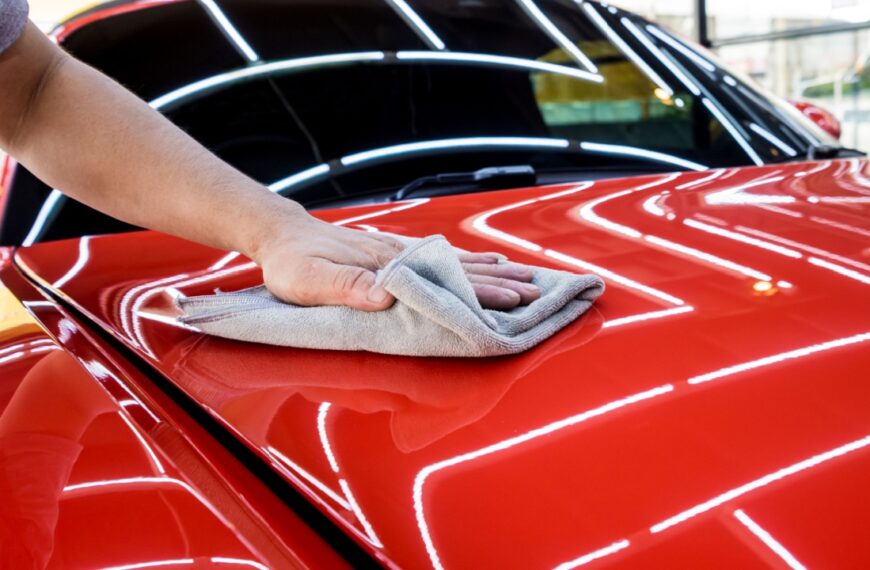 Car service worker polishing car with microfiber cloth