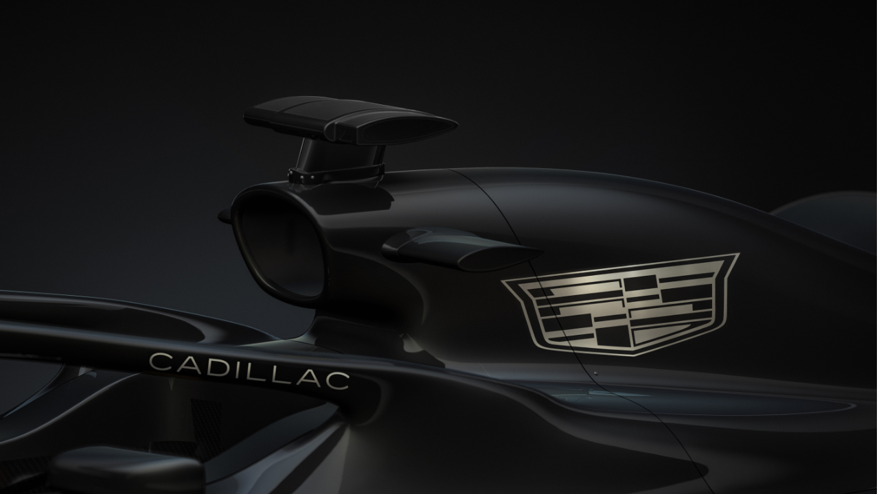 Close up of black Formula 1 race car with white Cadillac logo on engine cover and halo