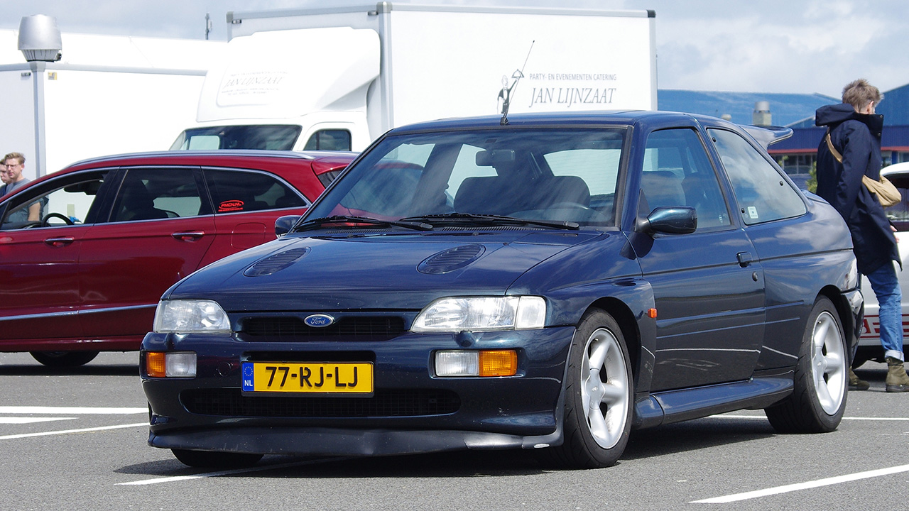 A Ford Escort RS Cosworth on a parking lot, front 3/4 view, rear wing delete