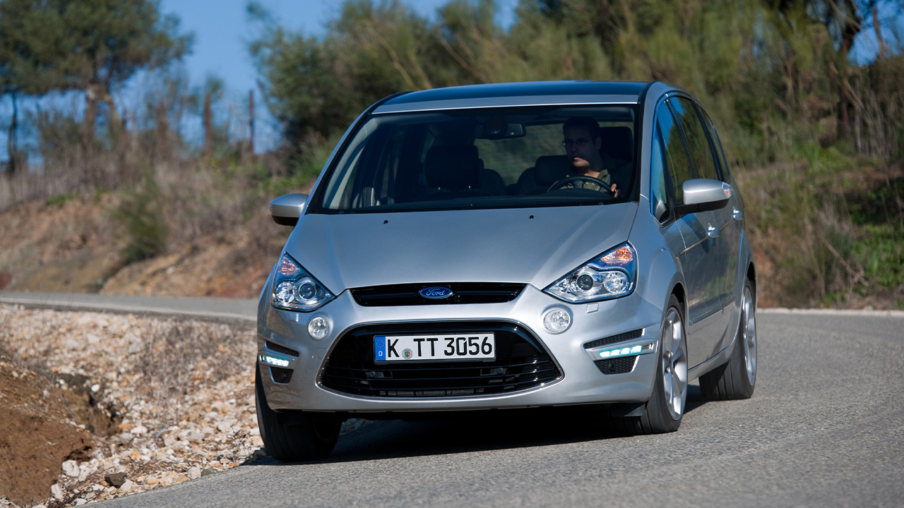 A silver Ford S-Max taking a corner vigorously, front 3/4 view