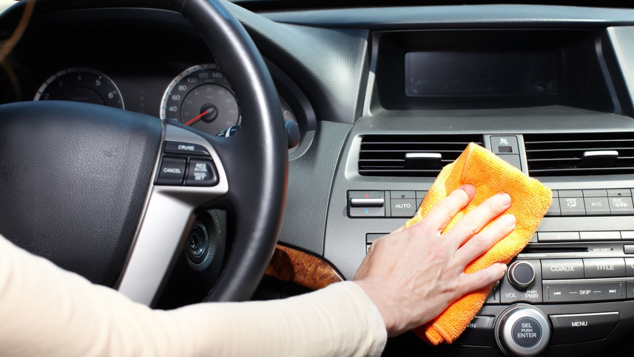 Hand with microfiber cloth cleaning car