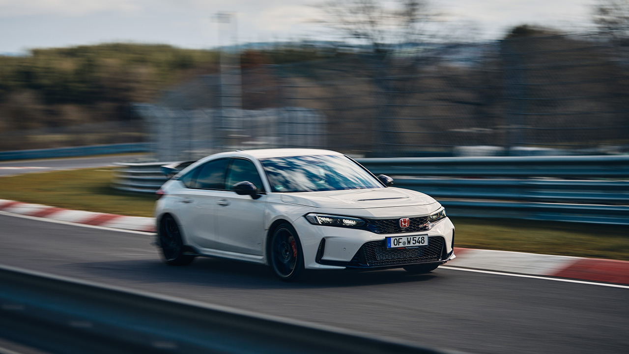 The new Honda Civic Type R in white on a racetrack, front 3/4 view