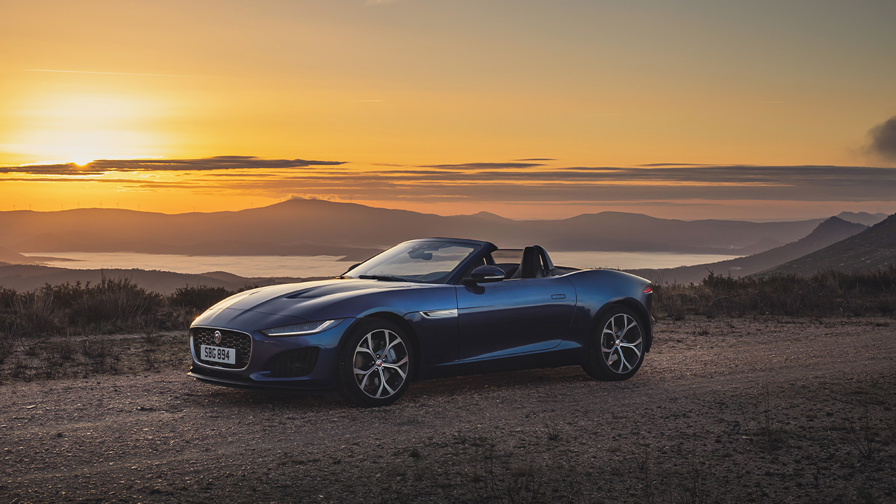 The Jaguar F-Type Convertible in blue during a sunset, front 3/4 view