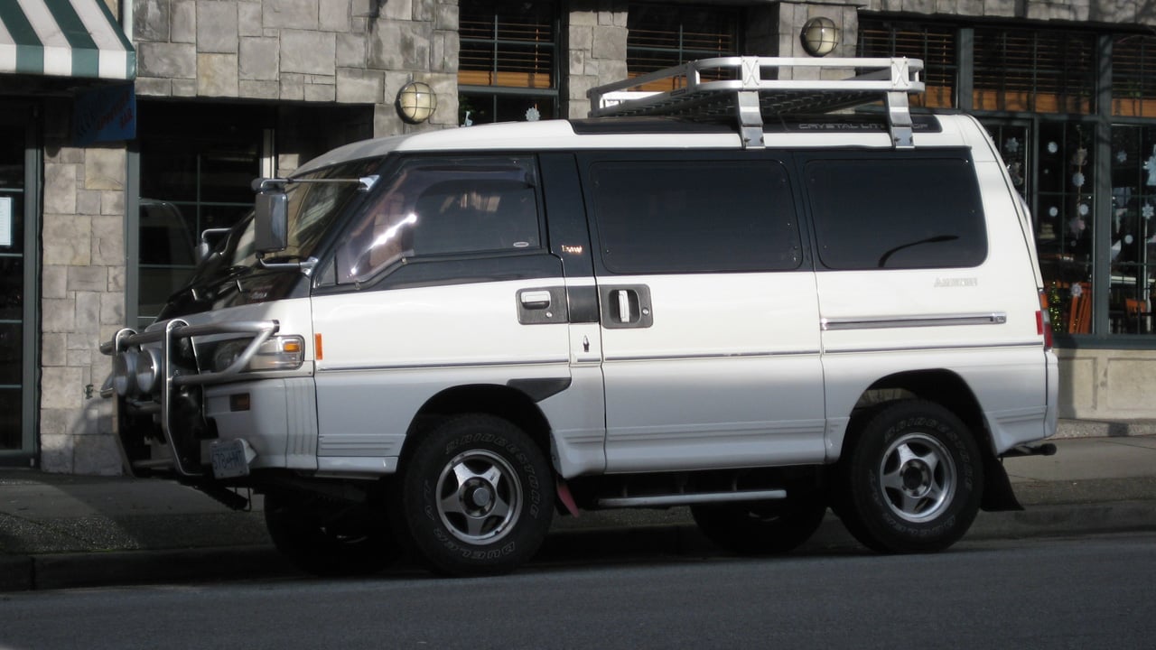 A street parked Mitsubishi Delica Star Wagon with exterior accessories, front 3/4 view