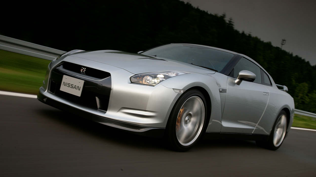 The original R35 Nissan GT-R in silver on a raceetrack, front 3/4 view