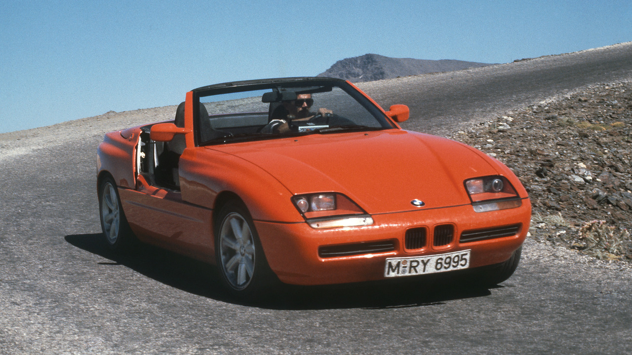 Red 1988 BMW Z1 Driving Down Road With Doors Retracted Front 3/4 View