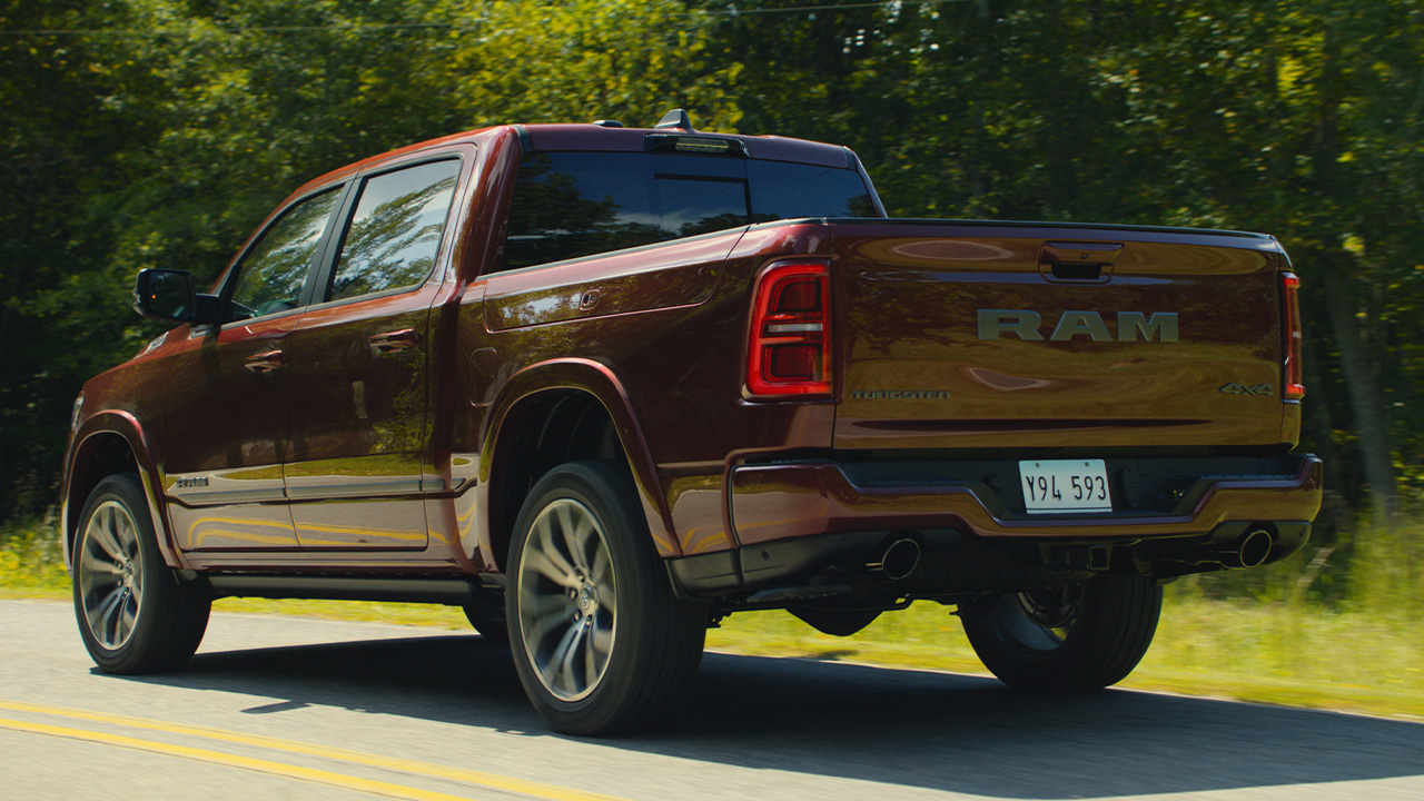The RAM 1500 Tungsten in red on the move, rear 3/4 view