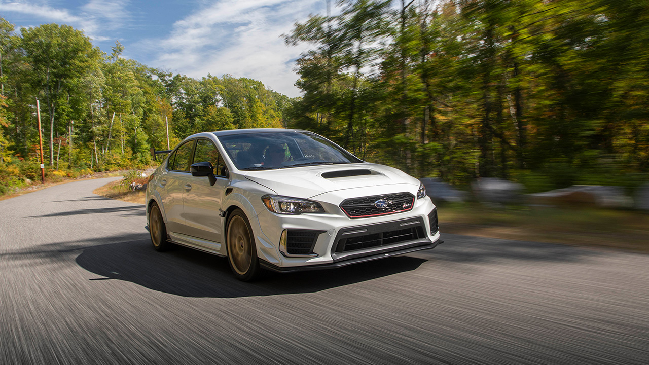 A white Subaru Impreza WRX STI on the move, front 3/4 view