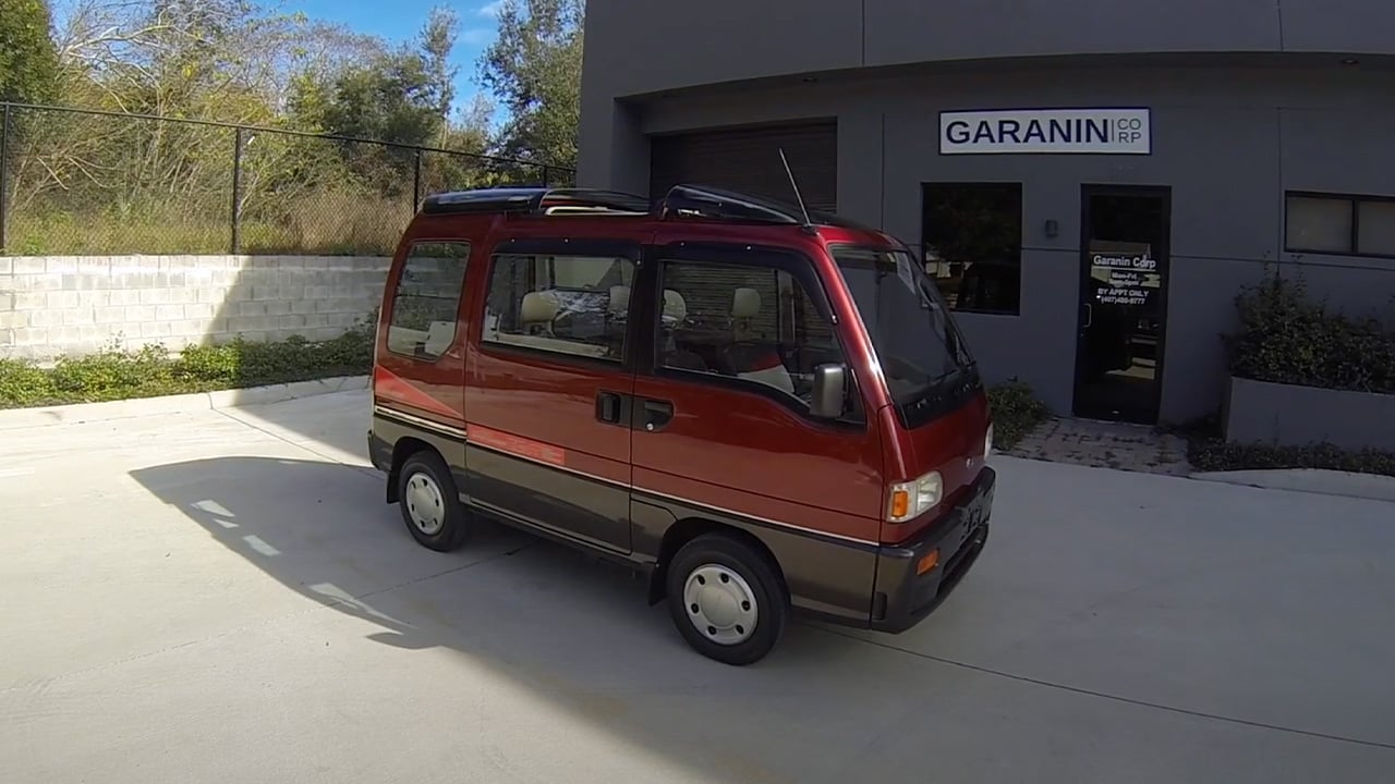 A two-tone red over gray Subaru Sambar van, front 3/4 view