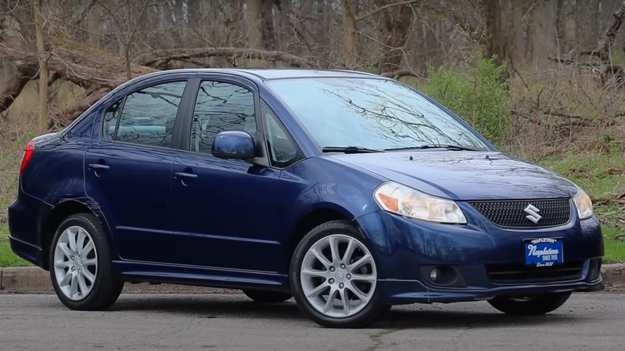 A blue Suzuki SX4 sedan, front 3/4 view