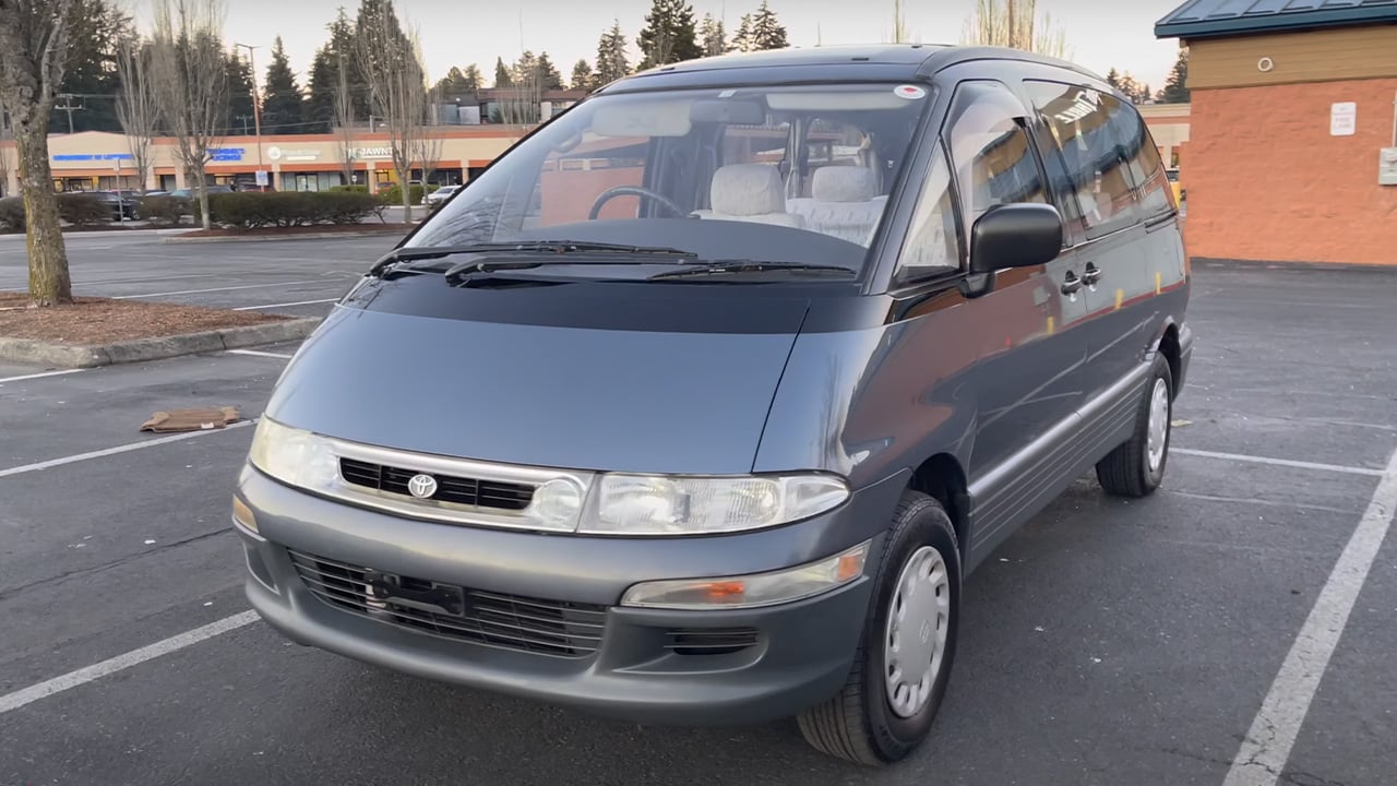 A gray JDM spec Toyota Estima Previa on a parking lot, front 3/4 view