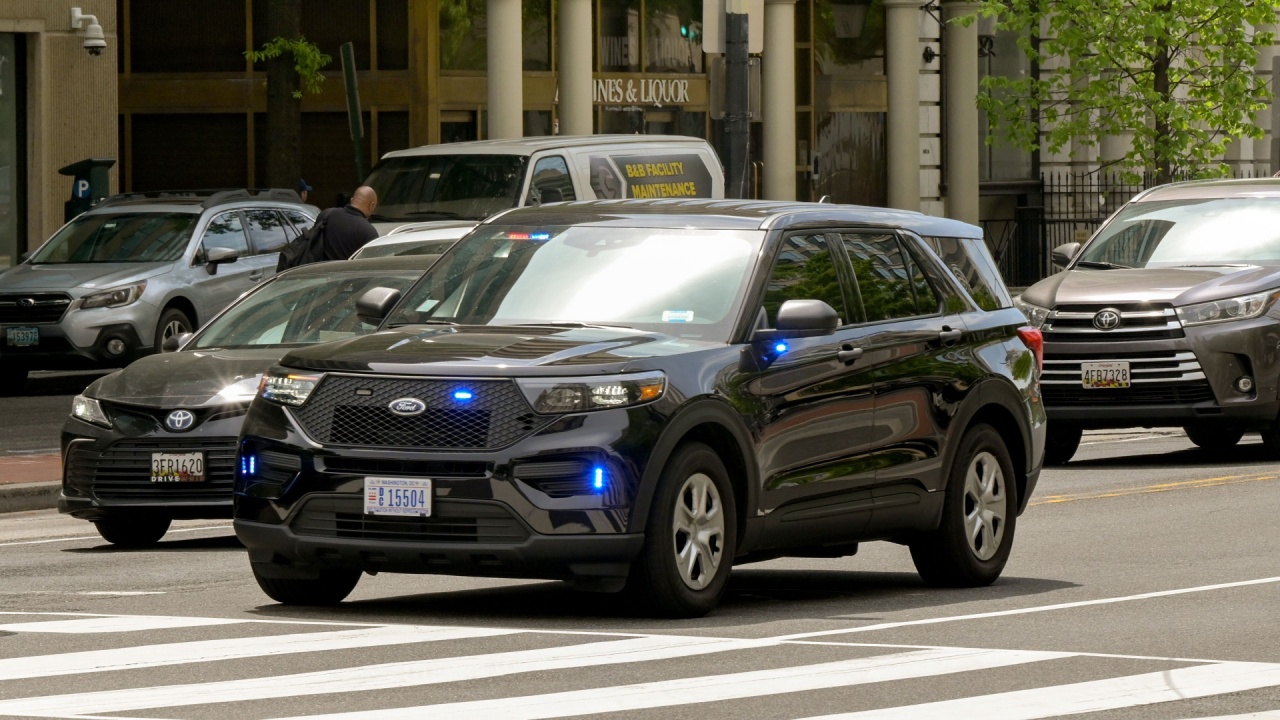 Unmarked police car with emergency lights flashing driving on a street