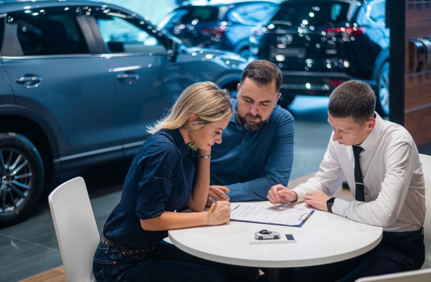 Happy caucasian couple signs a contract for the purchase of a car salon.