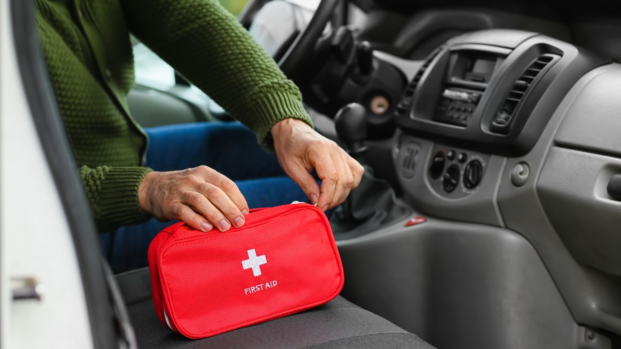 Man with first aid kit in car