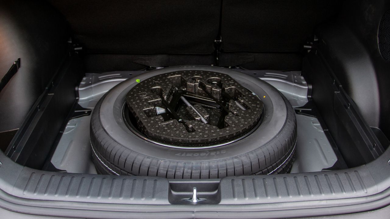 Spare wheel in the trunk of a modern car. Jack lifting and a spare tire in rear of car.