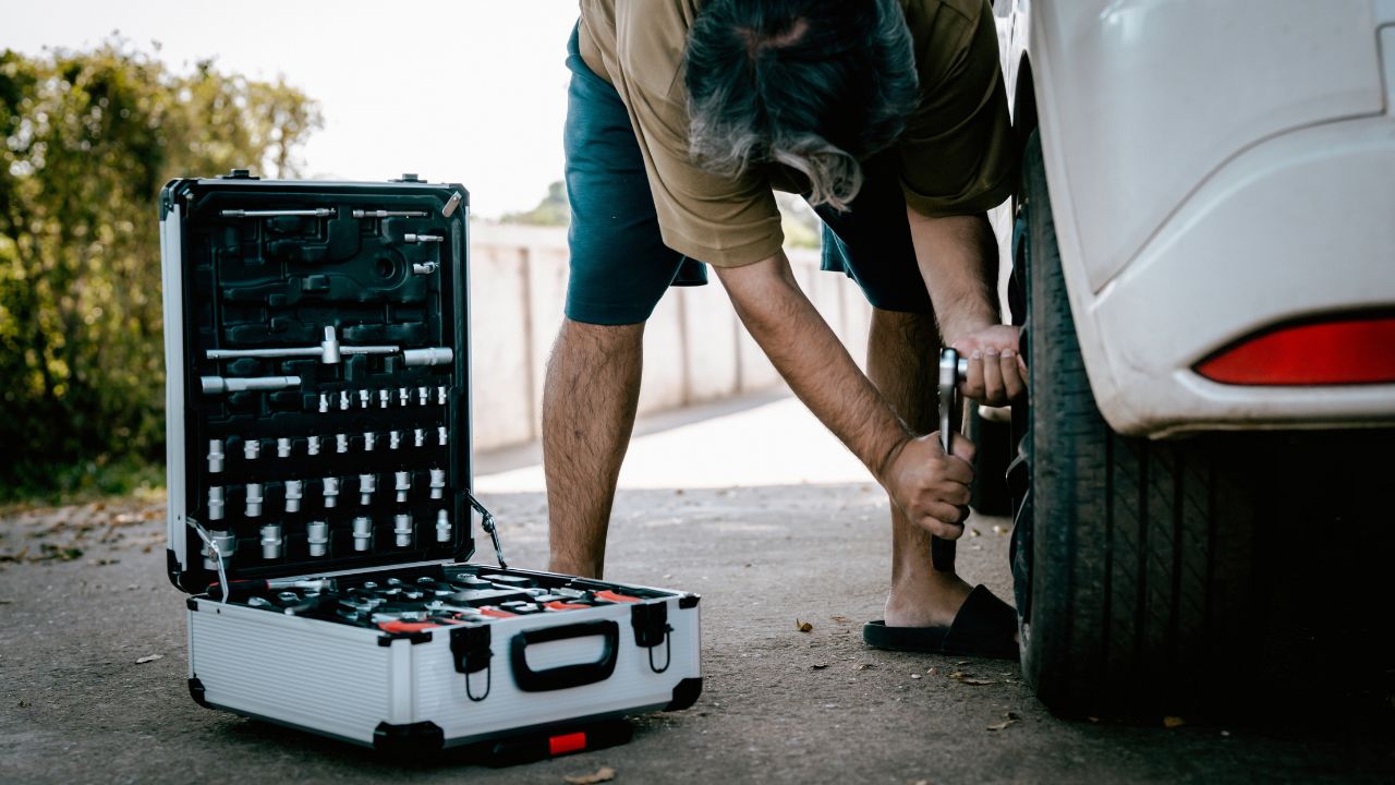 Man fixing a car using a hardware toolbox Set of maintenance tools, wrenches, screwdrivers, you can buy them online or in a garage.