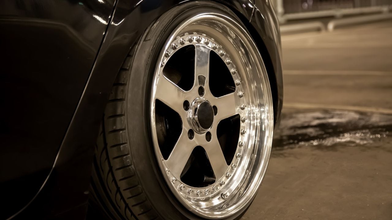 Alloy polished rims of a sports car. Wide wheels with stretched tires. Tuned low car