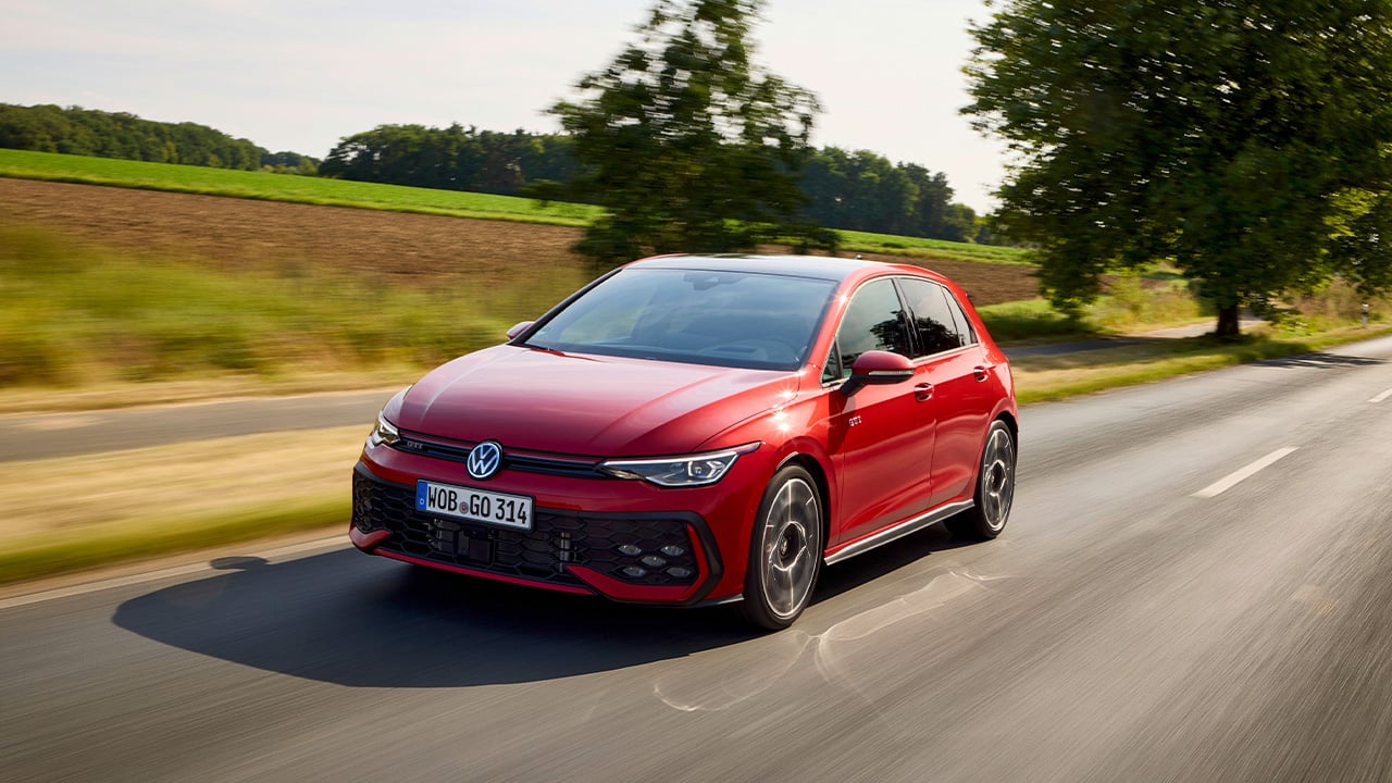 A red Volkswagen Golf GTI Mk8 on the move, front 3/4 view