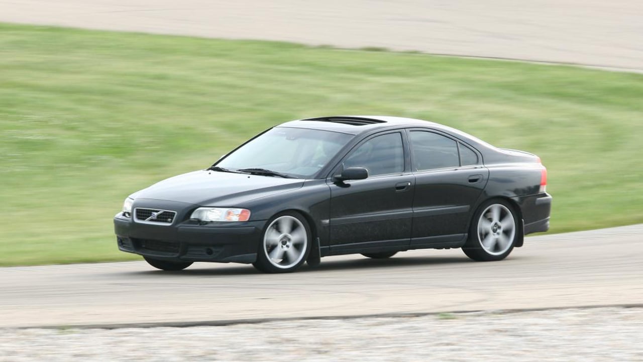 A black Volvo S60 R on a racetrack taking a corner, front 3/4 view